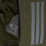 Mochila deportiva Adidas modelo Power VIII, color verde oliva con base negra. Presenta el logo de la marca y las tres tiras características en la parte frontal en color gris reflectante. Cuenta con compartimento principal con cierre, correas laterales ajustables y bolsillos laterales.