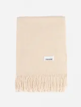 Pashmina de textura suave en color beige, con diseño liso y terminación de flecos en los extremos. Incluye etiqueta de marca cosida.