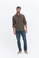 Camisa de manga larga color azul marino, confeccionada en algodón con textura, cuenta con un bolsillo frontal y cierre frontal con botones.