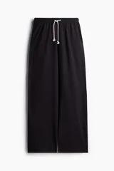 Pantalón de jogging de corte amplio, confeccionado en punto de algodón suave. Presenta cintura elástica con cordón de ajuste y bolsillos laterales.