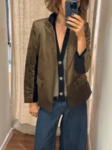 Blazer negro de simil terciopelo con cuello y puños en color marrón. Tiene bolsillos delanteros y forro estampado.