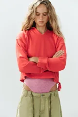 Sudadera de algodón rojo con efecto lavado, cuello redondo con capucha y abertura en V, manga larga y bajo ajustable con cordones.