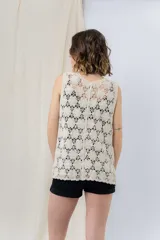 Chaleco tejido calado color crudo con escote en V y cierre frontal con botones.