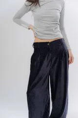 Pantalon de corte holgado y estilo bombacho, confeccionado en tela suave con ligero brillo. Presenta cintura elastizada en la parte trasera y puños elásticos en los tobillos que definen su silueta.