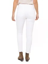 Jeans skinny de tiro medio color blanco, con cierre frontal, bolsillos delanteros con cierre y ruedo desflecado.