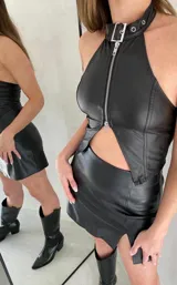 Top negro de cuero sintético con cuello halter, cierre frontal con cremallera y abertura en el abdomen.