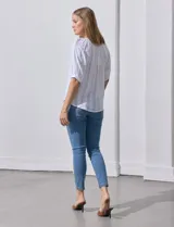 Blusa color fucsia con estampado de rayas verticales y flores, cuello redondo con escote en V y mangas cortas abullonadas.