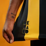 Camiseta de fútbol Puma del Club Atlético Peñarol, modelo Home, con franjas verticales amarillas y negras. Presenta cuello redondo con ribete negro y logo Puma en amarillo. Escudo del club en el pecho izquierdo.