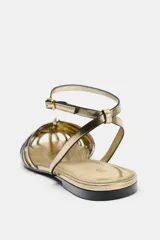 Sandalias planas tipo cangrejera en tono dorado metalizado, con múltiples tiras delanteras, tira ajustable en el tobillo con hebilla y suela baja.
