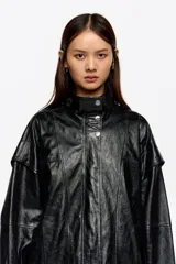 Cazadora de corte oversize confeccionada en piel, con cremallera metálica frontal oculta, cuello subido y manga larga con forma. Cuenta con bolsillos tipo alforja.