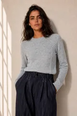 Sweater celeste melange de punto fino con cuello redondo y costuras decorativas frontales.