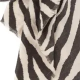 Pashmina rectangular con estampado animal print de cebra en tonos blanco y negro, con bordes desflecados.
