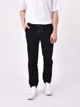 Pantalón jogger negro con cintura elástica ajustable con cordón y puños ajustados.