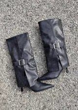 Botas de caña alta color gris, con diseño de solapa plegada y hebilla metálica plateada en el lateral. Presentan punta fina y taco kitten bajo.