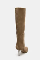 Bota de caña alta confeccionada en serraje color marrón, con diseño de punta fina y tacón alto tipo aguja. Presenta una estructura de calce fácil tipo pull-on.
