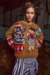 Sweater marrón de lana tejido a mano con cuello redondo y puños acanalados. Presenta apliques bordados de figuras infantiles.