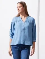 Blusa de manga tres cuartos color celeste claro, confeccionada en lyocell, con escote en V y detalle de frunces en el canesú y puños.