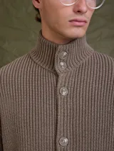 Sweater de punto grueso color azul marino, con cuello alto y cierre frontal de botones.
