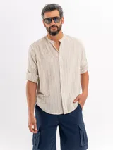 Camisola de manga larga color beige con diseño a rayas verticales blancas, cuello mao y cierre frontal con botones.