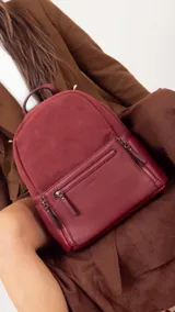 Mochila negra combinada con nobuck, bolsillo amplio adelante con broche y cierre, bolsillos en los costados, asas regulables y bolsillos internos.