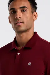 Polo de manga larga color bordó, con cuello camisero y cierre frontal de dos botones. Presenta el logo de la marca bordado en el pecho.