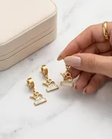 Caravanas de acero dorado con diseño de elefante calado y base rectangular con incrustación de nácar, con cierre tipo argolla.
