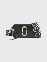 Cartera crossbody Marc Jacobs modelo The Snapshot, color tostado con herrajes dorados y logo frontal metálico. Incluye correa ajustable y extraíble con diseño de marca estampado.