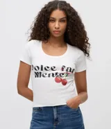 Remera baby tee de ribana blanca, de corte ajustado, con mangas cortas y cuello redondo. Presenta estampa frontal con la inscripción en negro 'dolce far niente' y diseño de cerezas con un lazo.