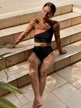 Top de bikini de un solo hombro con diseño bicolor, combinando negro y tostado. Está confeccionado en tejido de punto de alta calidad con propiedades de secado rápido y protección.