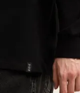 Remera de manga larga con cuello redondo, confeccionada en algodón. Presenta un corte comfort holgado y una pequeña etiqueta decorativa en el bajo.