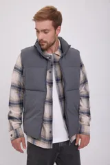 Chaleco puffer gris sin mangas con cuello alto y cierre de cremallera. Tiene bolsillos frontales y relleno de fibra sintética.