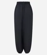 Pantalón de corte ballon con cintura alta elástica y diseño amplio. Presenta una caída fluida con terminaciones ajustadas en los tobillos que crean un efecto abalonado, confeccionado en tejido de poliéster con transparencia y forro interior.