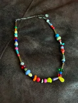 Collar largo confeccionado con cuentas multicolor de diversos materiales, formas y tamaños, incluyendo cristales checos, piedras naturales, acrílico y cerámica. Cuenta con cierre de cadena de acero quirúrgico y ganchito regulable.