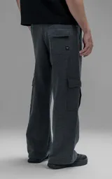 Pantalón tipo jogger gris melange de corte baggy y silueta amplia, confeccionado en frisa de algodón. Presenta cintura elástica, bolsillos laterales de mano y bolsillos estilo cargo con solapa y cierre en los laterales.