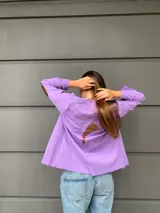 Cardigan tejido fino en lana color lila, con detalle de cintas y corte holgado.