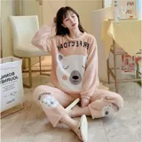 Conjunto de pijama de dos piezas confeccionado en tela de plush suave y abrigada. Incluye una remera de manga larga con diseño estampado de Totoro y pantalón largo a juego con puños en contraste.