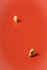 Aros tipo abridor con diseño de corazón en acabado mate dorado.
