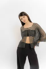 Blusa blanca de encaje con diseño de flores pequeñas entrelazadas, de corte holgado y mangas tres cuartos.