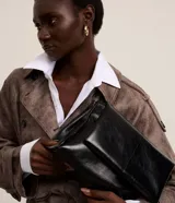 Cartera Satinato de hombro en tamaño mediano, confeccionada en poliuretano negro con acabado texturizado y diseño con solapa.