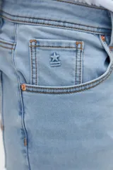 Jean slim fit de color celeste claro, con tiro medio y diseño clásico de cinco bolsillos.