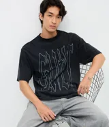 Remera de corte boxy en algodón color negro, con cuello redondo, mangas cortas y estampa frontal con lettering Guilt en color blanco.