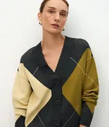 Cardigan de punto con diseño geométrico de rombos en tonos gris, verde oliva y crema. Presenta escote en V, cierre frontal con botones y mangas largas con puños acanalados.