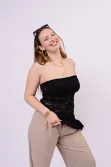 Top strapless de encaje negro con diseño ajustado y detalle de volados en el borde inferior.