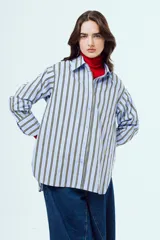 Camisa de manga larga con diseño a rayas verticales en tonos celestes y amarillos sobre fondo blanco, cuello camisero clásico y cierre frontal de botones.