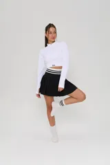 Pollera tableada de color negro con cintura elástica ancha en contraste, decorada con dos líneas horizontales blancas.