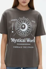 Remera de algodón manga corta, corte holgado, con cuello redondo y estampado frontal en negro con la frase "Travel through the universe" y motivos celestes de sol, luna y estrellas.