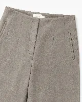 Pantalón de tiro alto y silueta amplia, confeccionado en tejido con textura suave tipo gamuza. Presenta diseño de pinzas frontales y bolsillos laterales integrados.