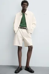 Cazadora de hombre color beige claro, de corte relajado, con cuello solapa, cierre frontal de cremallera y puños y bajo elásticos. Presenta una textura de rayas sutiles y efecto lavado.