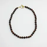 Collar de cuentas esféricas de piedra Ojo de Buey de 8 mm, con separadores de nudos en hilo color caramelo y cierre tipo T con baño de oro.
