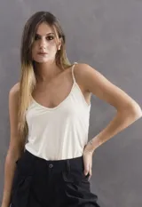 Musculosa de tela elastizada con breteles finos regulables y escote en V, diseñada para ser utilizada como prenda base o sola.